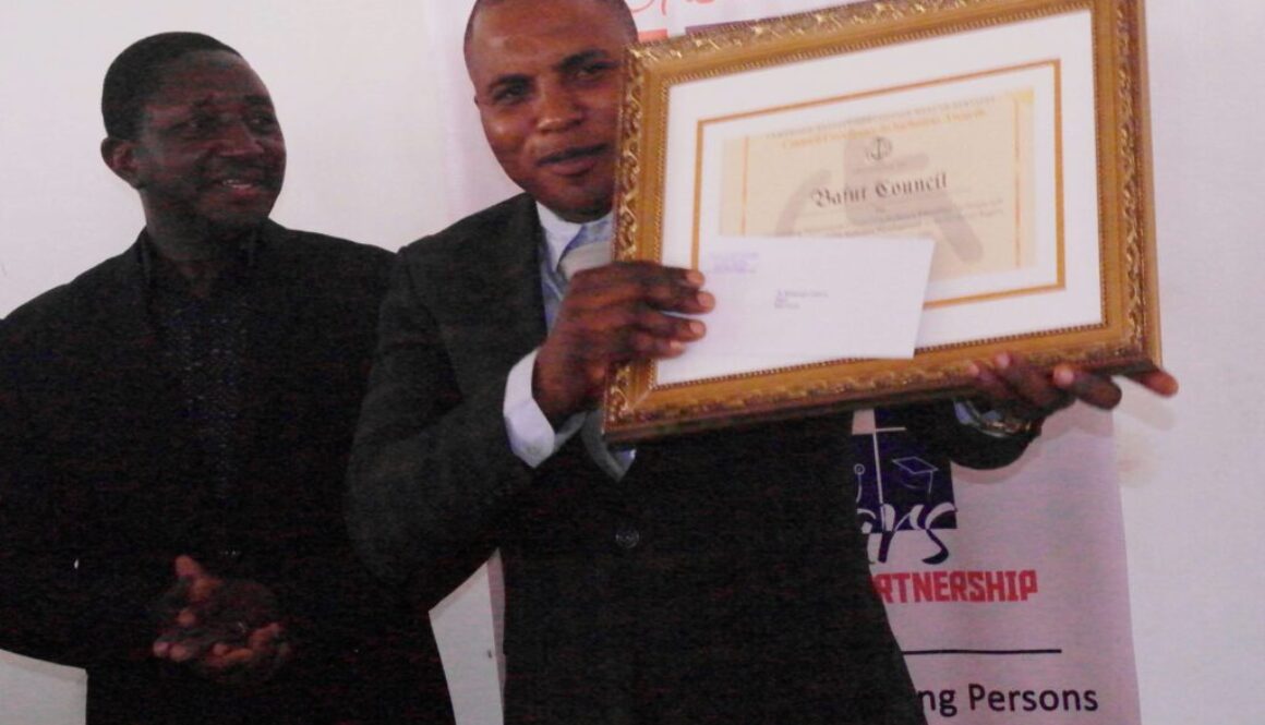 Bafut Council Mayor holding Award to Bafut Council for for Outstanding Performance in Promoting Inclusive Education and Disability Inclusive Development in the Northwest Region, Cameroon