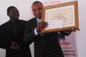 Bafut Council Mayor holding Award to Bafut Council for for Outstanding Performance in Promoting Inclusive Education and Disability Inclusive Development in the Northwest Region, Cameroon