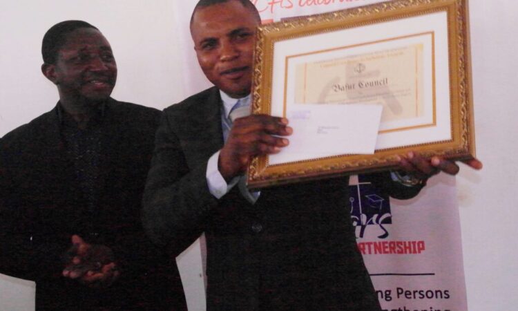 Bafut Council Mayor holding Award to Bafut Council for for Outstanding Performance in Promoting Inclusive Education and Disability Inclusive Development in the Northwest Region, Cameroon