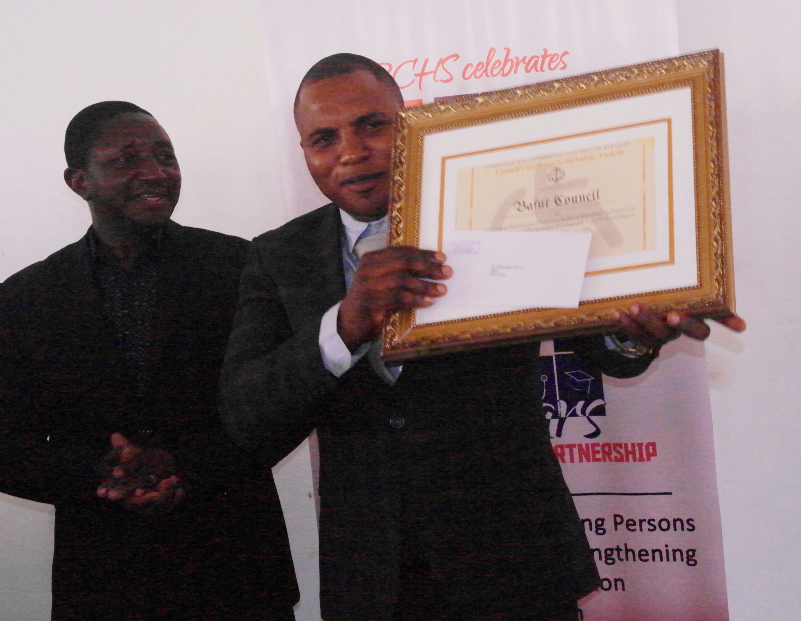 Bafut Council Mayor holding Award to Bafut Council for for Outstanding Performance in Promoting Inclusive Education and Disability Inclusive Development in the Northwest Region, Cameroon